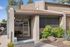 Glass front entrance to the Solaris at Shadow Mountain leasing office with desert landscaping.
