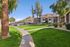 Winding sidewalk through a lush green lawn with mountain views in the background.