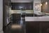 Elegant modern kitchen with dark wood cabinets, stainless steel appliances, and a spacious white countertop island.