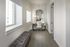 Elegant apartment hallway with a plush bench, large window, and stylish vanity with mirror, exuding luxury and comfort.