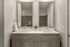 Elegant modern bathroom with dual sinks, sleek gray cabinetry, and stylish mirrors.