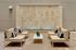 Elegant outdoor seating area with modern beige sofas, a sleek glass table, and minimalist decor set against a chic stone wall.