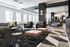 Luxurious modern living room with chic black and white decor, plush seating, and natural light streaming through expansive windows.