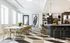 Chic and modern communal space featuring a long dining table with gold chairs, artistic wall decor, and a sleek bar area with contemporary lighting.