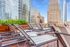 Luxurious rooftop lounge with stylish striped loungers and vibrant city skyline views, perfect for relaxation.