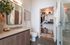 Elegant bathroom with sleek double vanity, modern fixtures, and access to a spacious walk-in closet, offering a blend of luxury and functionality.