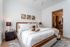 Sophisticated bedroom with plush bedding, elegant artwork, and en-suite bathroom, offering a serene and inviting living space.