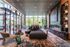 Stunning modern living room with floor-to-ceiling windows, elegant fireplace, plush seating, and artistic decor.