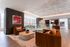Luxurious apartment lounge with elegant lighting, chic brown sofas, contemporary artwork, and a stylish dining area.
