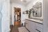 Elegant bathroom with a modern vanity, large mirror, and lush greenery, leading to a spacious walk-in closet.