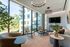 Modern living room with large windows, stylish furniture, and greenery offering a bright and inviting atmosphere.
