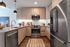 Modern kitchen featuring sleek stainless steel appliances, elegant wood cabinetry, and a stylish open layout with chic lighting.