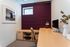 Chic home office with modern furniture, elegant decor, and a stylish purple feature wall.
