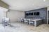 Contemporary outdoor lounge area with sleek bar seating, modern pebble stone wall, and wall-mounted TVs.