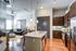 Modern open-concept living space featuring a gourmet kitchen with dark wood cabinetry, granite countertops, and a cozy living area with stylish furnishings.