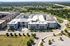 Cedar Park apartment community from above with four story buildings, surface parking, and tree lined street