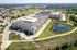 Cedar Park apartment buildings beside a pond with paved walking trail and open lawn