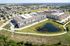 Cedar Park apartment buildings wrapping a pond with walking trail and rows of surface parking