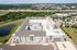 Cedar Park apartment rooftops and balconies with pond, parking lot, and highway retail beyond