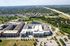 Cedar Park apartment community from above with adjacent greenbelt trails, pond, and highway access