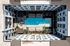Courtyard pool from above with lounge chairs, turf lawn, and shaded seating at a Cedar Park apartment