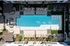 Courtyard pool from above with tanning ledge, lounge chairs, turf lawn, and shaded seating area