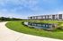 Walking trail beside the community pond with four story apartment buildings in Cedar Park