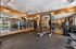 Fitness center with squat rack, free weights, dumbbell racks, mirrored wall, and rubber flooring