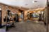 Fitness center with cable weight machines, brick accent wall, wall mounted TV, and rubber flooring