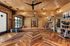 Stretch and yoga room with herringbone wood flooring, mirrored wall, dumbbells, and stacked yoga mats