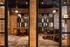 Coworking suite with glass walled conference rooms, private desk, pendant lighting, and brick walls