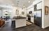 Kitchen with island seating, black countertop, stainless refrigerator and range, and wood plank flooring