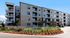 Apartment building exterior in Cedar Park with private balconies, fenced patios, and landscaped beds