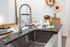 Kitchen with stainless apron front sink, gray countertop, and pull down spring faucet