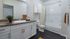 Bathroom with granite-like vanity, white cabinets and tub with shower