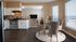 Kitchen with stainless range beside a dining area with round table and windows