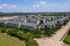 Aerial of apartment community, tree-lined streets and city skyline, Houston, TX