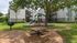 Playground with slide, picnic table and grill under shade trees