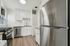 Sleek modern kitchen with white cabinetry, stainless steel appliances, and elegant wood flooring.