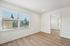 Bright and airy room with large windows, elegant light wood flooring, and minimalist white walls, perfect for modern living.