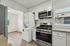 Modern kitchen with stainless steel appliances, stacked washer-dryer, and elegant granite countertops.