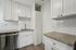 Modern kitchen with sleek white cabinetry, stainless steel dishwasher, and elegant granite countertops, radiating contemporary charm.
