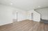 Bright and modern living space with sleek wooden flooring, neutral walls, and staircase, offering a fresh and inviting atmosphere.
