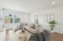 Bright and modern living room with large windows, stylish beige sectional sofa, and elegant wooden accents, ideal for relaxation and gatherings.