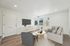 Contemporary living room with sleek wooden floors, plush L-shaped sofa, and modern decor bathed in natural light.