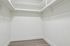Spacious walk-in closet with ample hanging space and elegant wood flooring, perfect for organizing your wardrobe.