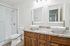 Elegant bathroom showcasing dual vessel sinks, granite countertop, and a modern glass-enclosed shower.