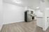 Modern apartment kitchen with sleek stainless steel appliances, elegant white cabinetry, and stylish wood flooring.