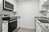 Modern kitchen with sleek stainless steel appliances, elegant granite countertops, and stylish white cabinetry.