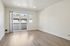 Bright and spacious living area with sleek wood flooring and access to a private balcony through sliding glass doors.